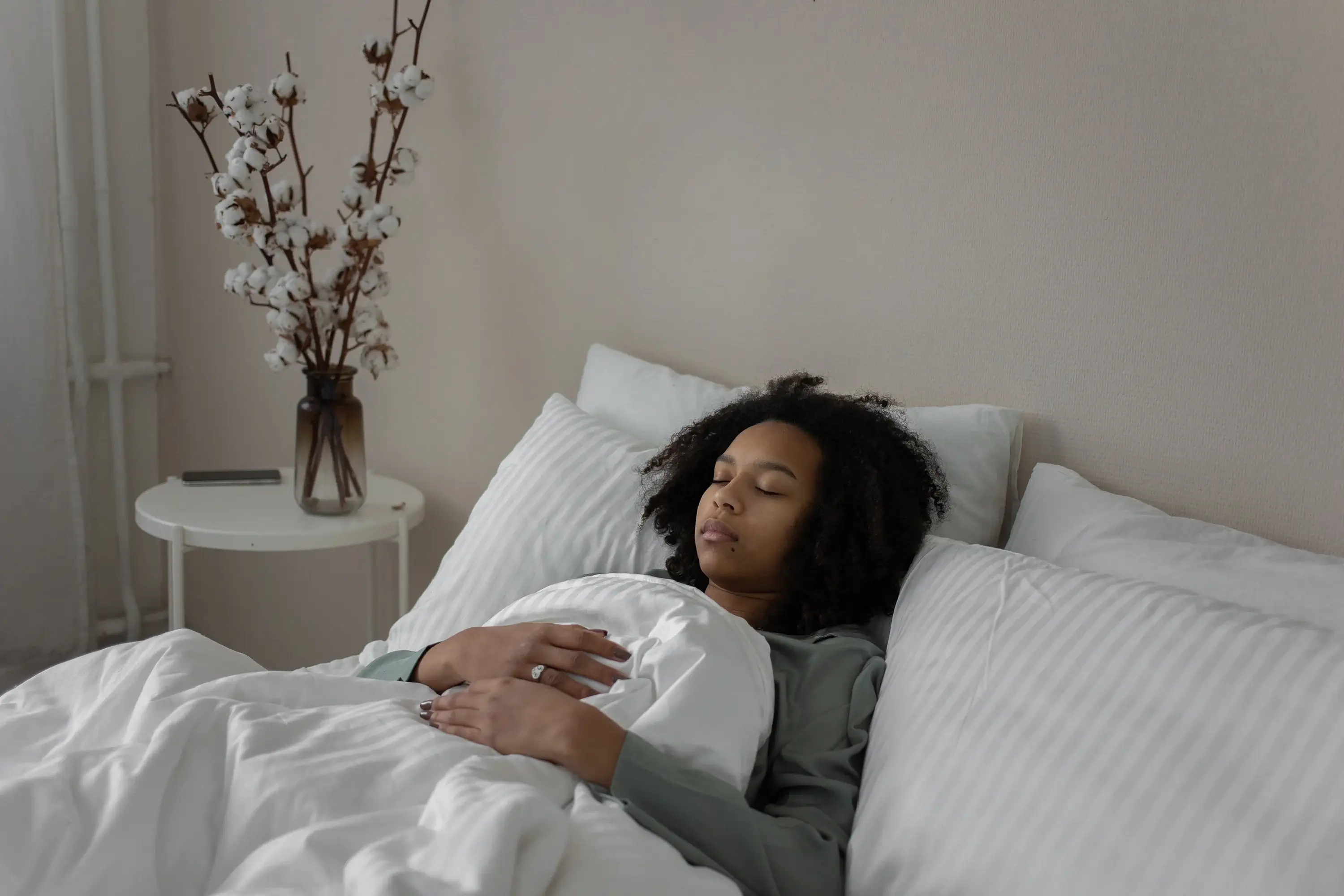 woman laying in bef with her eyes closed